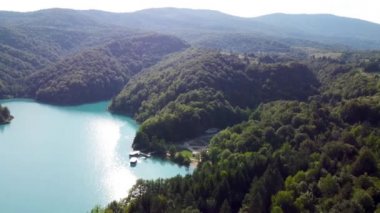 Drone Hırvatistan 'da Plitvice Lakes Ulusal Parkı' nı vurdu. Hırvatistan 'ın orta kesimindeki orman rezervi şelaleler ve kireçtaşı kanyonla birbirine bağlı bir göl. Göller arasında yürüyüş parkurları. Bir orman.