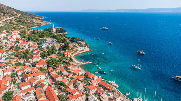 Drone shot on the Croatian resort island of Hvar in the Adriatic Sea. View from the drone to the port. Boats and ships on the shores of the Adriatic Sea in Croatia. Mountains on the island of Hvar.