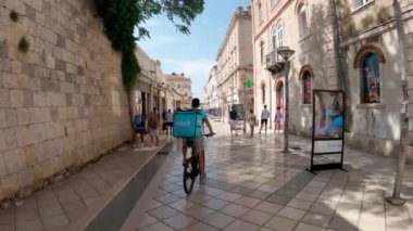 Croatian city of Split in the resort region of Dalmatia. A busy street in the spa town of Split. Tiled road in Croatia. A colorful street in the city center with a mamnya road