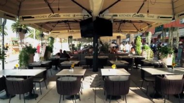 People sit in a restaurant on the waterfront in Split. People eat and drink drinks in a cafe in the city of Split. Cafes and restaurants along the boulevard in Split Croatia.