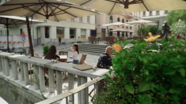 Ljubljanica nehri boyunca Ljubljana 'da açık hava kafeleri bulunmaktadır. Ljubljana Slovenya 'nın başkenti ve en büyük şehridir. İnsanlar bir kafede yemek yer. 