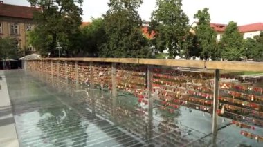 Ljubljana 'daki Kasap Köprüsü. Ljubljana 'daki Ljubljana nehri üzerindeki yaya köprüsü. Ljubljana 'da sevgililer köprüsü. Korkuluk boyunca aşıkların kilitleri birbirlerine olan bağlılığımızın ve sevgimizin bir göstergesi..
