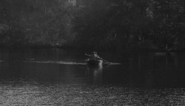 Gölde binen bir adamın siyah beyaz görüntüsü..