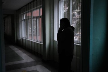 Kyiv, Ukrayna: 24 Şubat 2022: Koridorda telefonla konuşan yaşlı kadın