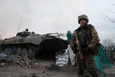 Lukyanivka, Ukrayna: 25 Mart 2022: Tank yakınlarındaki Ukrayna toprak savunma savaşçıları