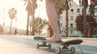 Gün batımında çıplak ayakla kaykaya binmek.