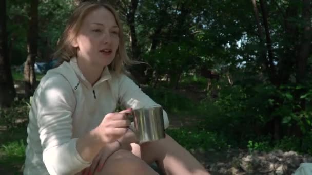 Красивая молодая белая женщина берет и пьет из кемпинга стальная кружка — стоковое видео