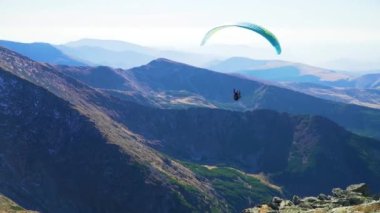 Paraglide uçuş dersi ve atlama ve yüksek bir dağ zirvesinden havalanma manzaralı sıradağlarda. Mükemmel aktif tatil hedefi