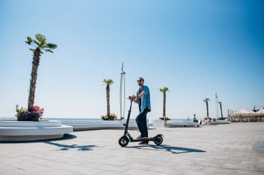 Mobiletle gezen adam güneşli toprak seti gökyüzü çocuğu San