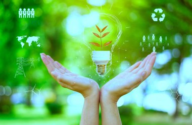 İnsan eli yeşil ampulü tutuyor, dünya kavramını kurtarmak için. Simgelerle CO2 emisyon kavramını azaltmak, küresel ısınma