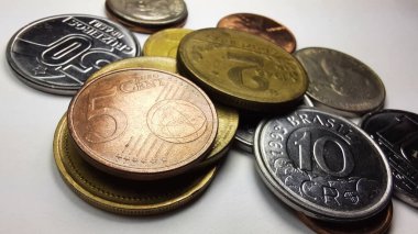 5 Euro cents coin with a collection of various old coins on a white background.
