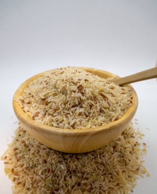 Yasemin pirinç tohumları bir fincanda pirinç rengi arka planda ahşap kaşık