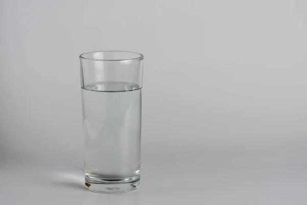Glass with water on a white table.