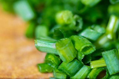 Soğan yaprakları kesme tahtasının üzerinde doğranmıştı.