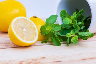 Limon ve nane, ahşap bir masaya yerleştirilmiş.