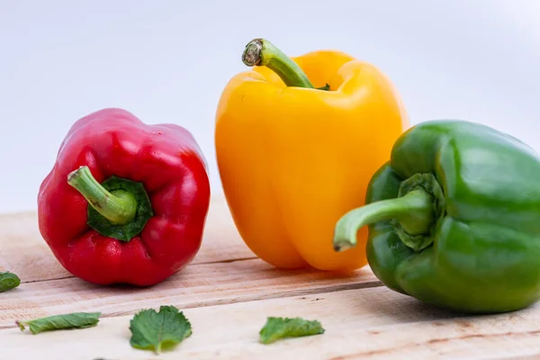 Ahşap masaya konmuş renkli biberler