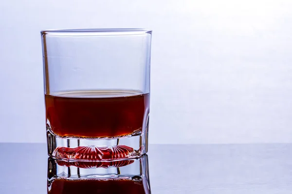 Glass of whiskey on a glass table