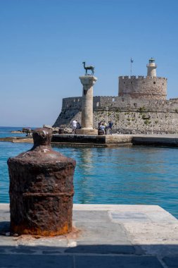 Rodos, Yunanistan 'daki Mandraki' deki Rodos limanındaki Doe heykellerini ziyaret eden turistler.