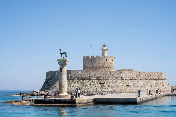 Rodos, Yunanistan 'daki Mandraki' deki Rodos limanındaki Doe heykellerini ziyaret eden turistler.