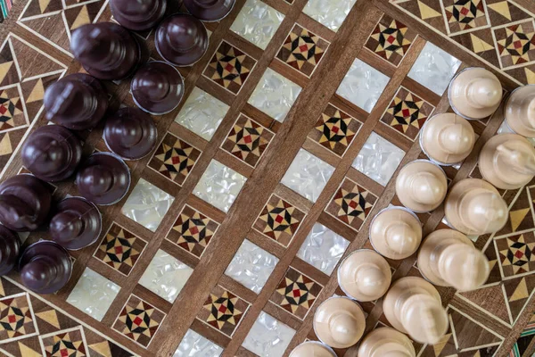 Top view of a chess game on old peeled of colored wooden table