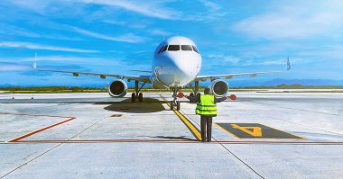Ramp agent steering a plane into its parking spot.