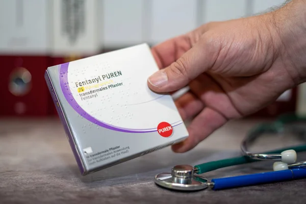 Şiddetli ağrı tedavisi için fentanil içeren bir kutu Fentanil. Masada ve arka planda farklı tıp kitapları var..