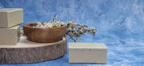 Side view Aleppo soap and dray Laurus nobilis flower in a wooden plate .