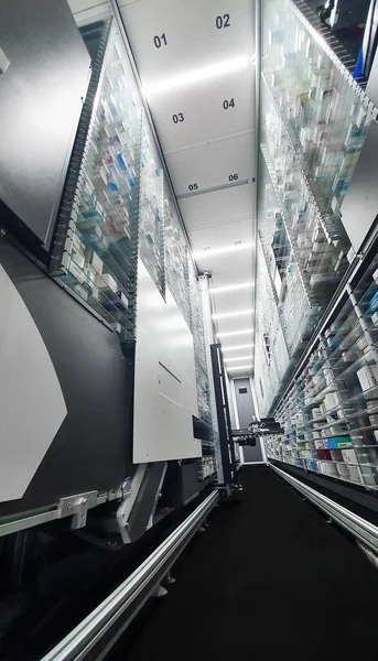 Modern eczane deposu ve bir robot el bir eczanede uyuşturucu düzenliyor ve depoluyor..