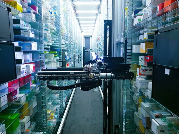 Modern eczane deposu ve bir robot el bir eczanede uyuşturucu düzenliyor ve depoluyor..