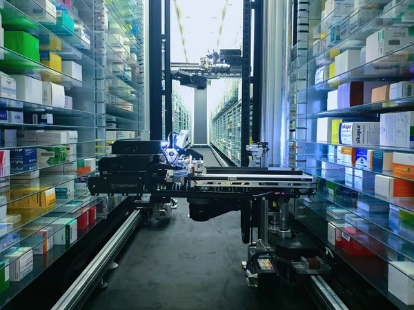 Modern eczane deposu ve bir robot el bir eczanede uyuşturucu düzenliyor ve depoluyor..