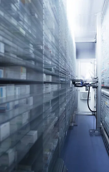 Modern eczane deposu ve bir robot el bir eczanede uyuşturucu düzenliyor ve depoluyor..