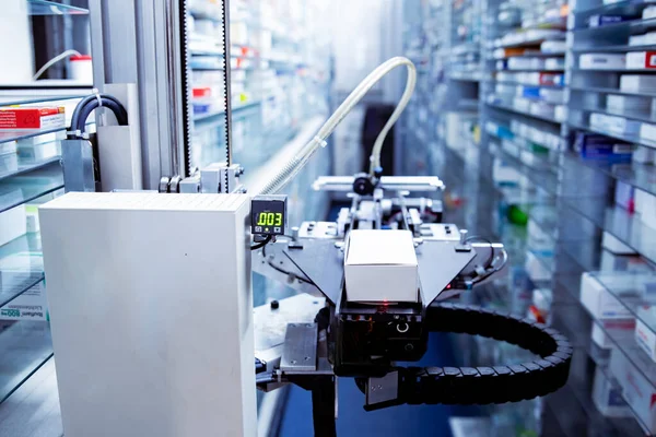 Modern eczane deposu ve bir robot el bir eczanede uyuşturucu düzenliyor ve depoluyor..