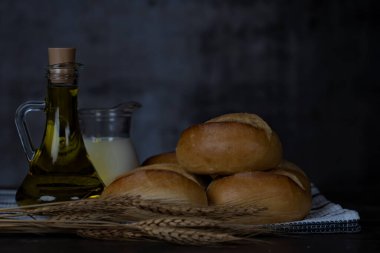 Ekmek ruloları, süt, ahşap masa üzerinde zeytinyağı. Kahvaltı ya da yemek pişirme konsepti..