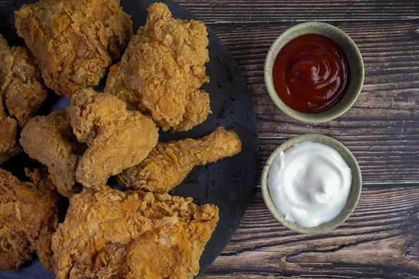 Ketçaplı kızarmış tavuk ve ahşap masaya sarımsaklı sos..