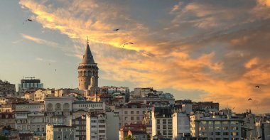 Cityscape of a part of Istanbul city showing homes and Galata tower at sunset 