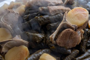 Hot just finished cooked Plate of stuffed grape leaves called Dolma , made from vines with rice, meat and spices.