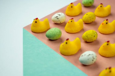 Düz arkaplanda paskalya tavuğu şekilli şeker ve yumurta. Paskalya bayramı şekeri kavramı..