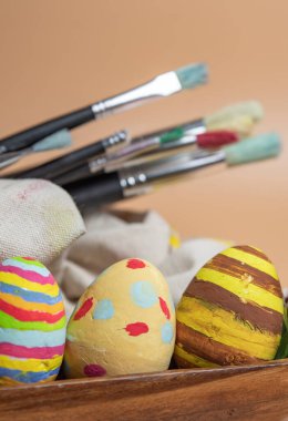 Boya fırçaları ve renkli Paskalya yumurtaları yakın.