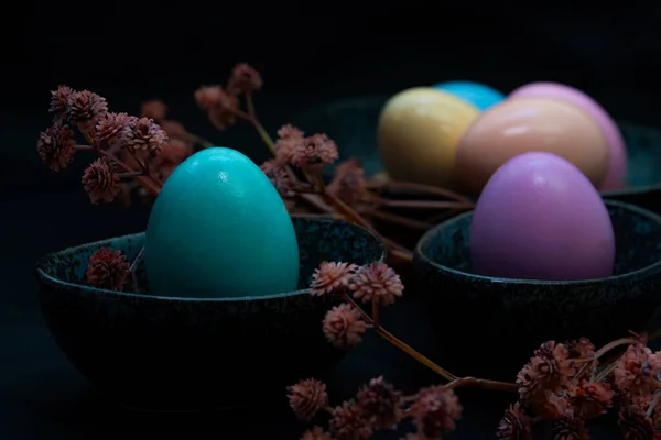 黑色背景的深色花岗岩板中的花朵和彩色复活节彩蛋 — 图库照片