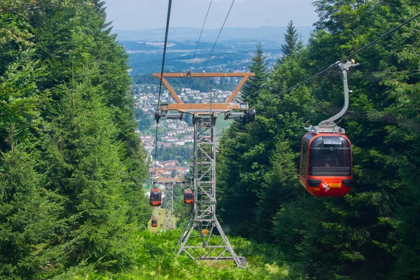 Alpler 'deki manzara taze yeşil çayırlar, güneşli bir gün mavi gökyüzü ve baharda bulutlar.