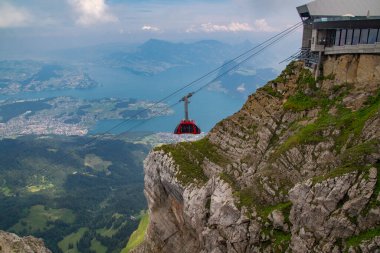 Gondol asansörü ya da hava tramvayı turistleri İsviçre 'deki bir dağın tepesine çıkarıyor. 