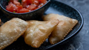 Samosa, baharatlı patates, soğan, bezelye, peynir, sığır eti ve diğer et gibi lezzetli dolgusu olan bir kızarmış veya fırında hamur işidir.
