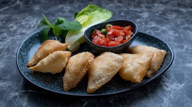 Samosa, baharatlı patates, soğan, bezelye, peynir, sığır eti ve diğer et gibi lezzetli dolgusu olan bir kızarmış veya fırında hamur işidir.