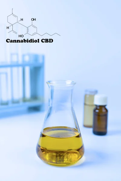 Cannabidiol (CBD) oil in glass beaker cool tone light name and chemical structure.