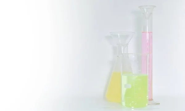 Φιάλη Και Ογκομετρικός Κύλινδρος Ροζ Πράσινο Και Κίτρινο Νερό Ποτήρι — Φωτογραφία Αρχείου