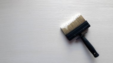 Beyaz renkli duvar fırçası ve beyaz ahşap masa..