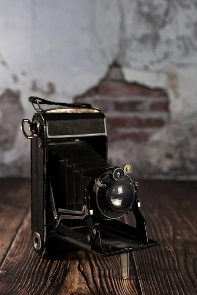 Old film camera on a wooden background