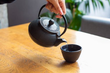 Kadın çaydanlıktan fincana çay dolduruyor. Çin çay töreni.. 