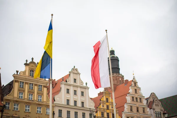 Polonya, Wroclaw - Nisan 2022. Pazar Meydanı, Ukrayna ve Polonya 'nın bayrakları bina yakınında.