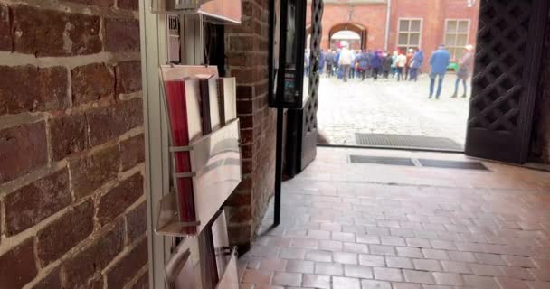 Touristin wählt Büchlein am Eingang des Museums. — Stockvideo